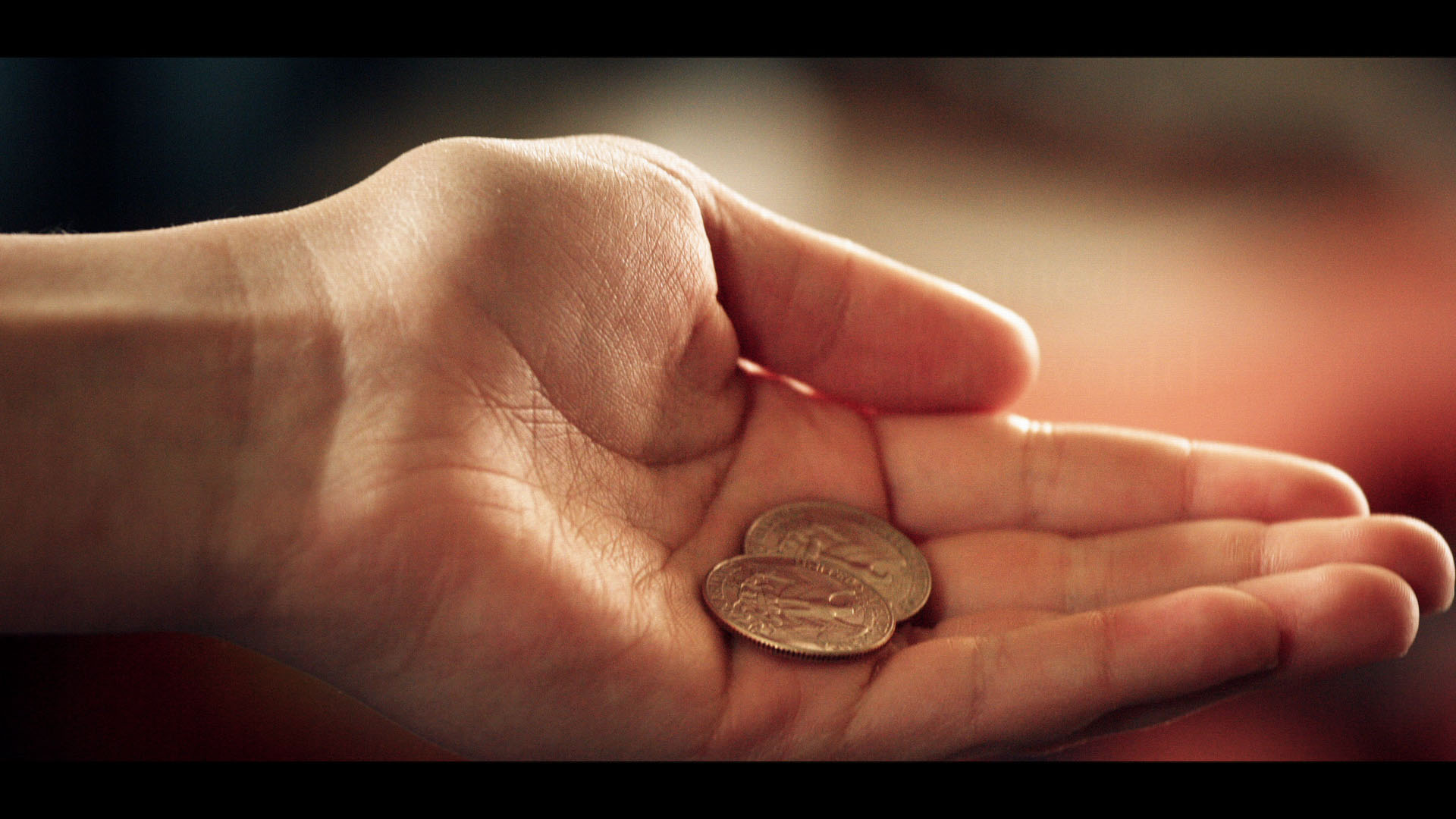 A photo of a hand with two coins in the palm.