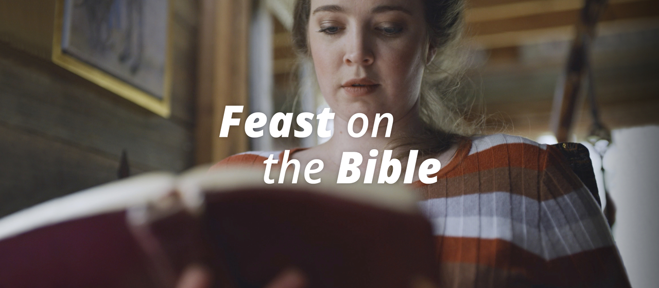 A woman studies the Bible sitting in his living room