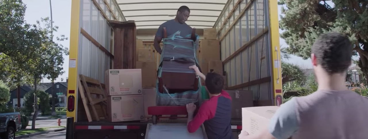 Men help a neighbor move their belongings in a moving van
