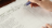 hands writing on form