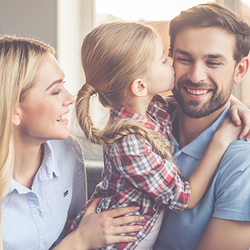 A couple play with their young daughter teaching her that family is forever