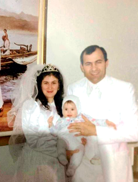 Husband, wife and baby dressed in white at the temple - The Duro Family (Romania)