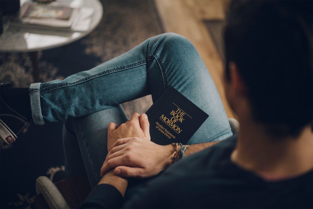 Homme avec un Livre de Mormon sur les genoux