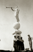 statue of the angel Moroni with four workmen standing at base