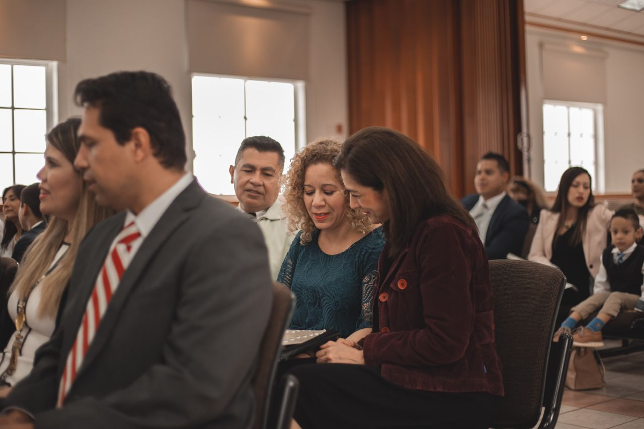 Personas participando en la reunión sacramental