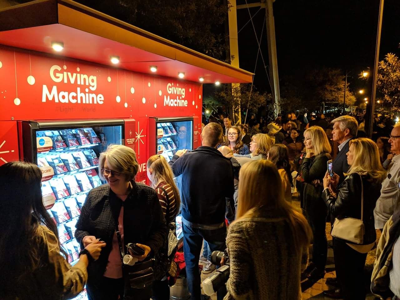 People donating at a Light the World Giving Machine