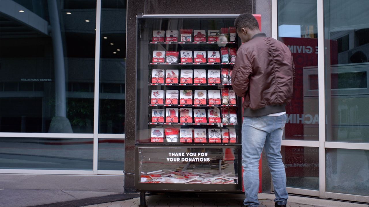 A man stands by a giving machine contemplating what to donate