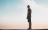a lone man standing on a mountain