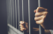 Hands holding cell bars