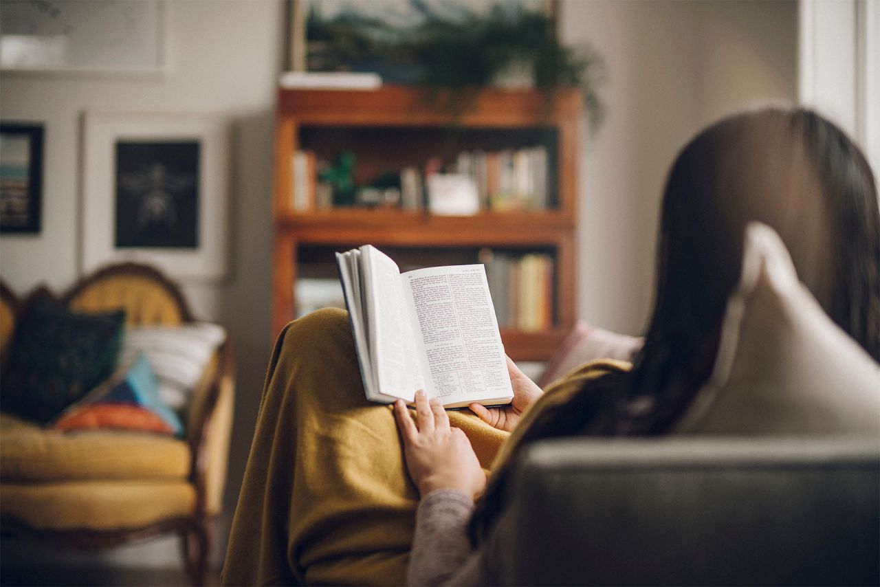 Fillette lisant le livre de Mormon sur un canapé
