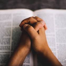 Hands resting on an open set of scriptures