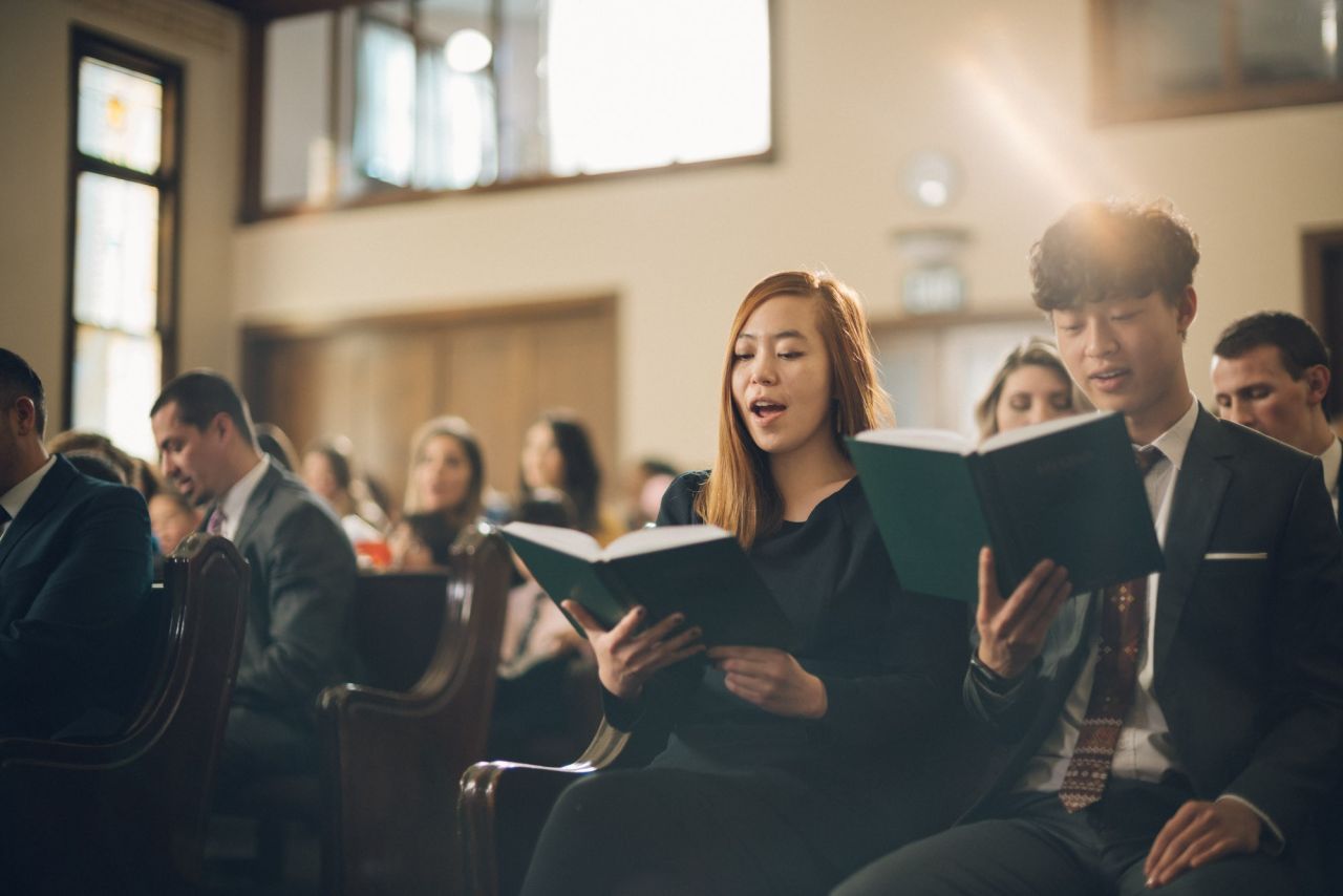 A couple singing hymns together with the congregation during church