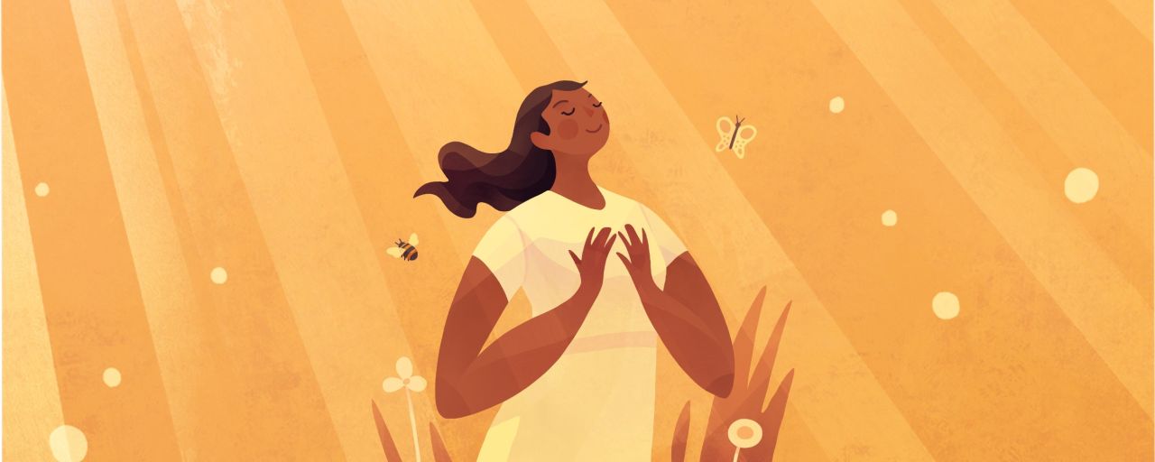 A young woman stands smiling in a field enjoying the gospel of Jesus Christ