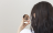 woman looking at herself in a compact hand mirror