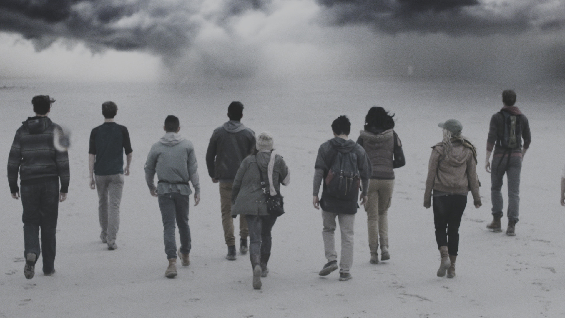 Nine teenagers walk through a fog