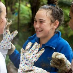 Two girls weed a garden preforming service for a neighbor