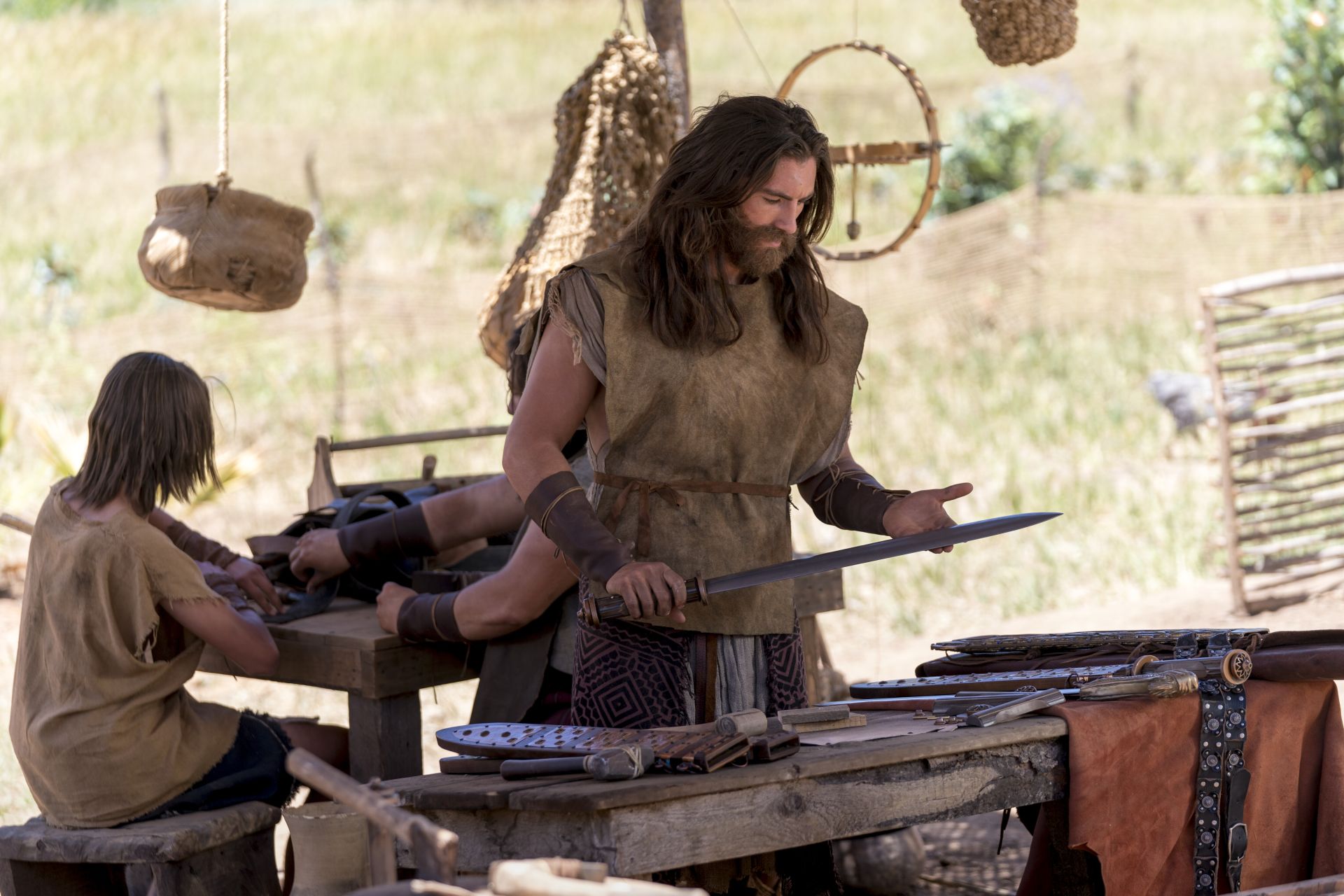 Nephi inspecting a sword and other weapons