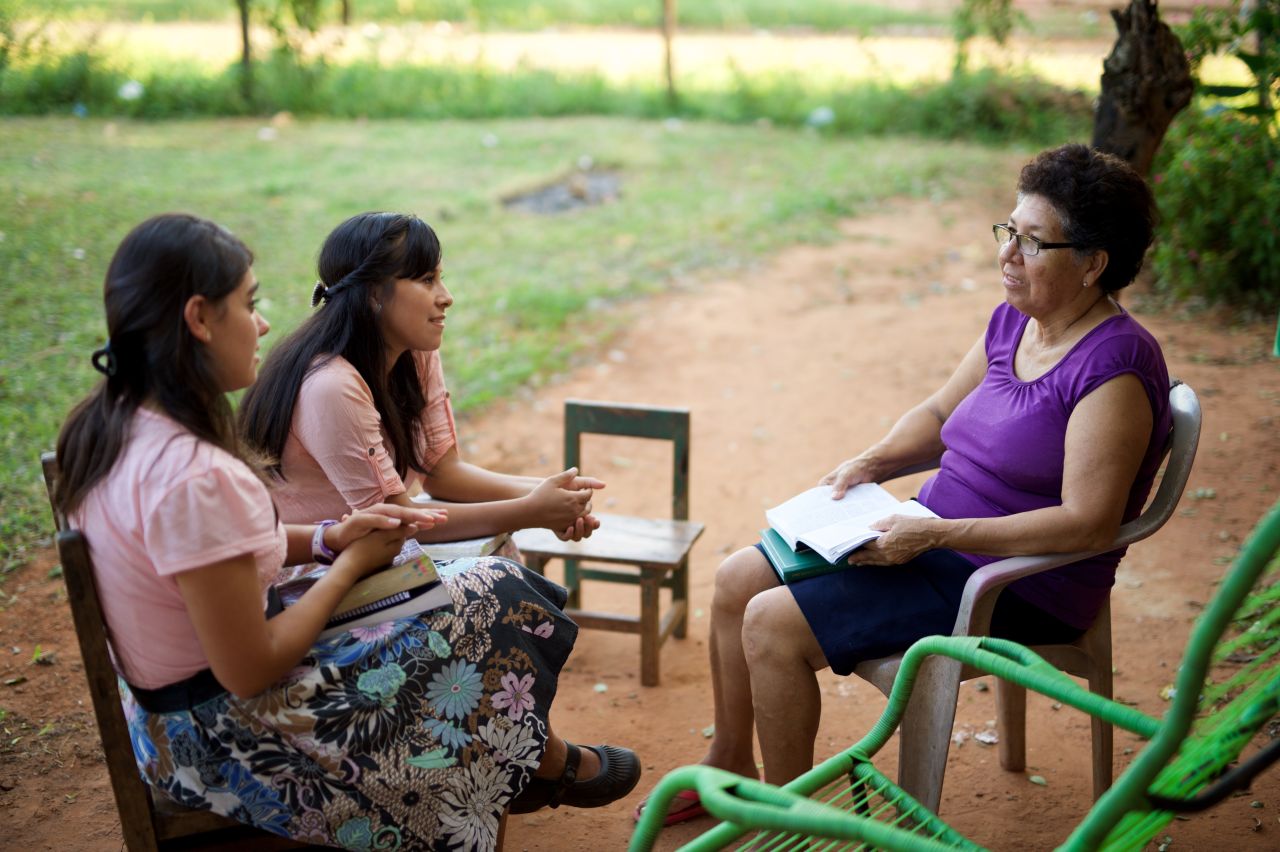 par de hermanas misioneras enseñando a una mujer