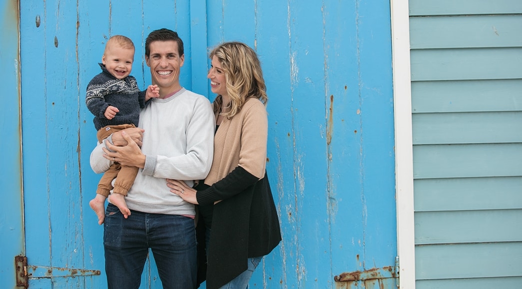 Steve and Whitney sit with their young child on the beach explain the blessings of the Book of Mormon