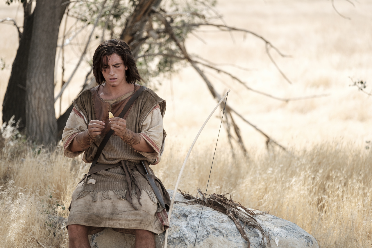 Nephi making a bow and arrow in the wilderness