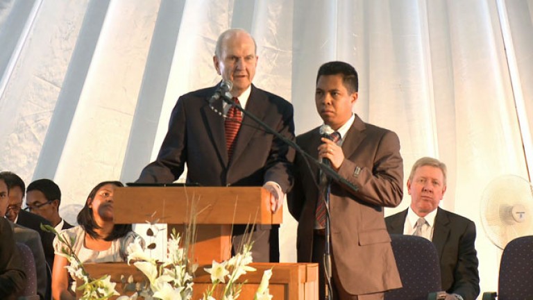 Elder Nelson speaks from a pulpit with a translator next to him