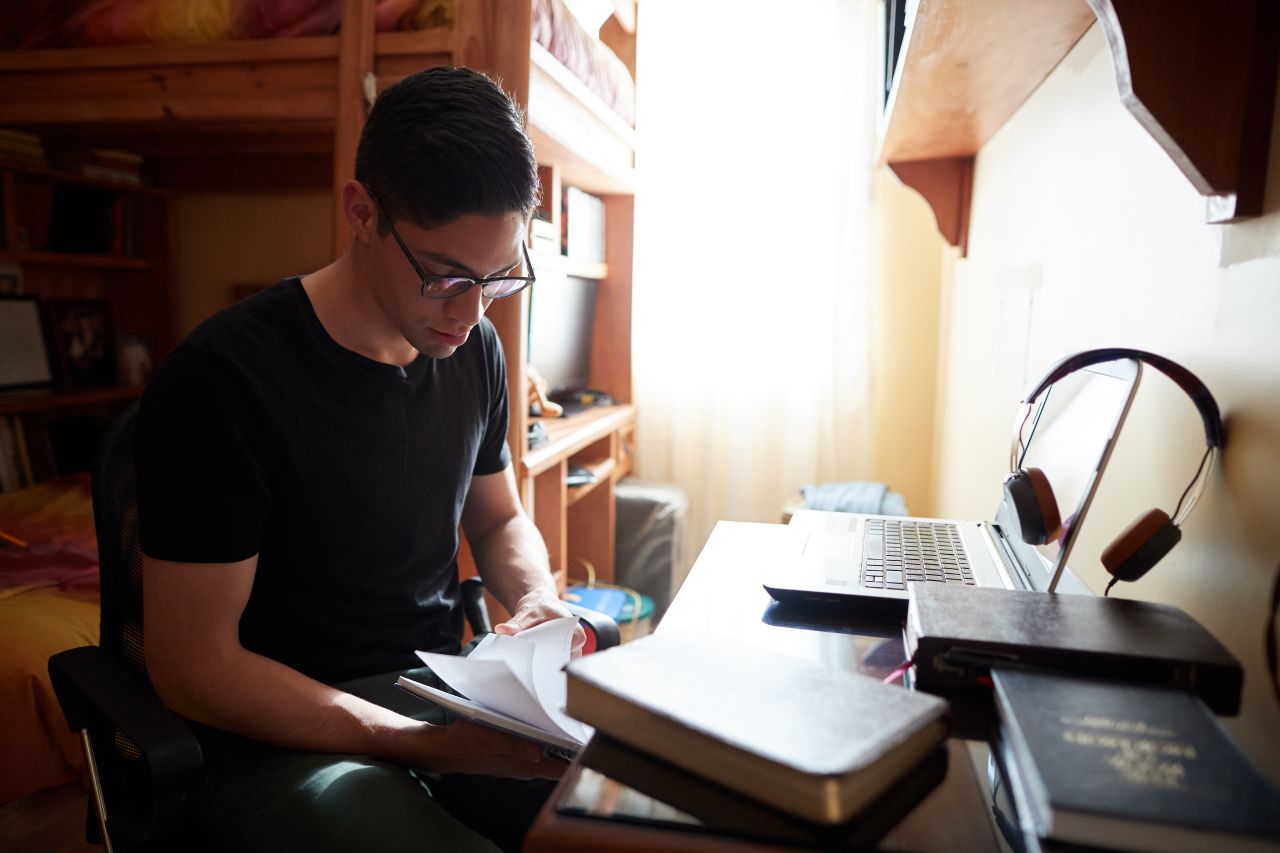 A young woman studying on a laptop.