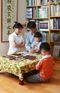 A photograph by Hyun-Gyu Lee of a family of four in Korea kneeling around a table for family prayer.