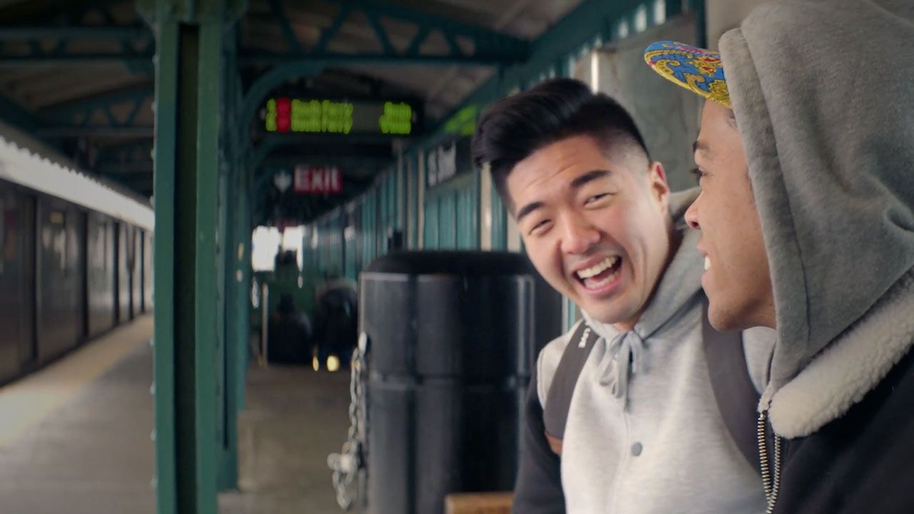 Two men sit on a bench in a train station enjoying each others company talking about the right christian church