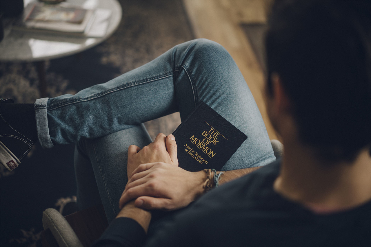 Homme avec un Livre de Mormon sur les genoux