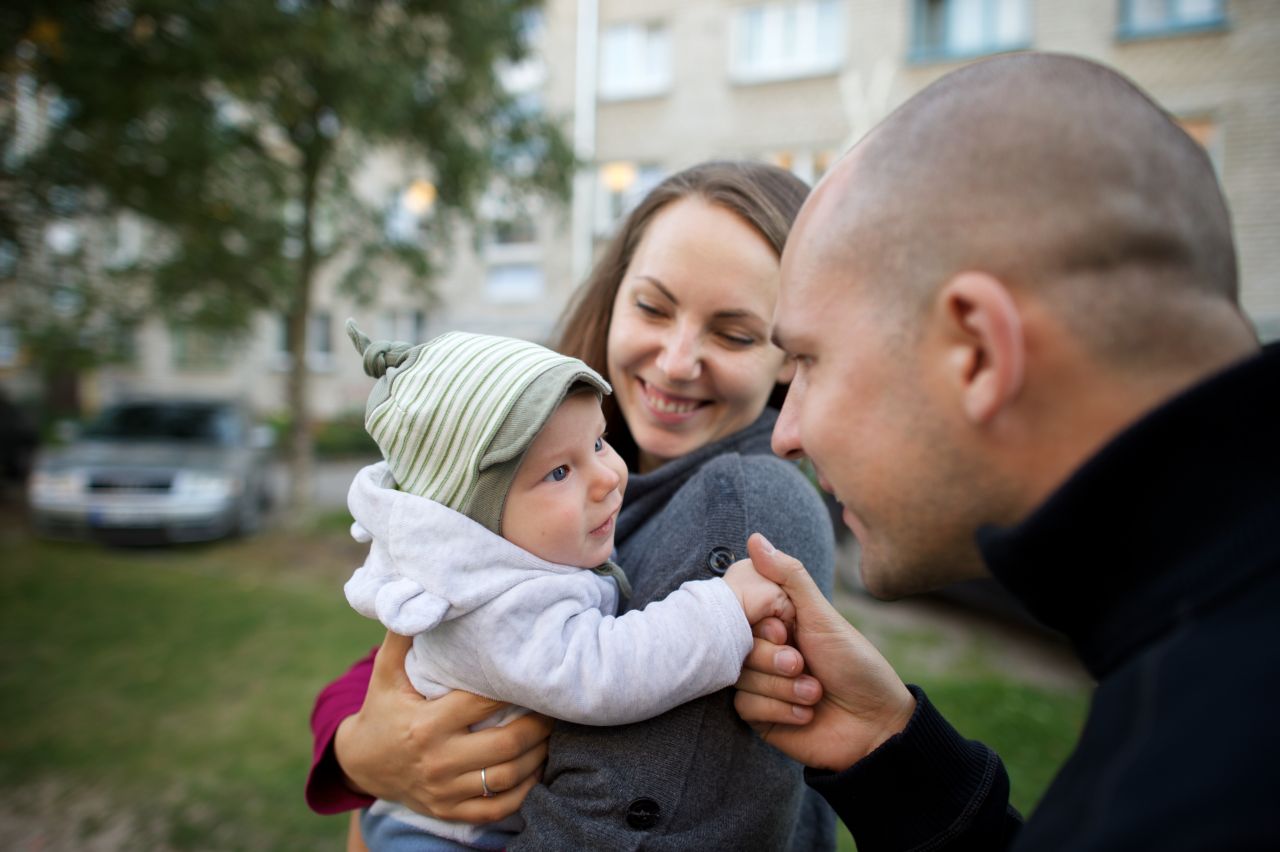 A young couple hold their newborn baby