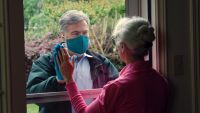 A man visits his elderly mother while social distancing