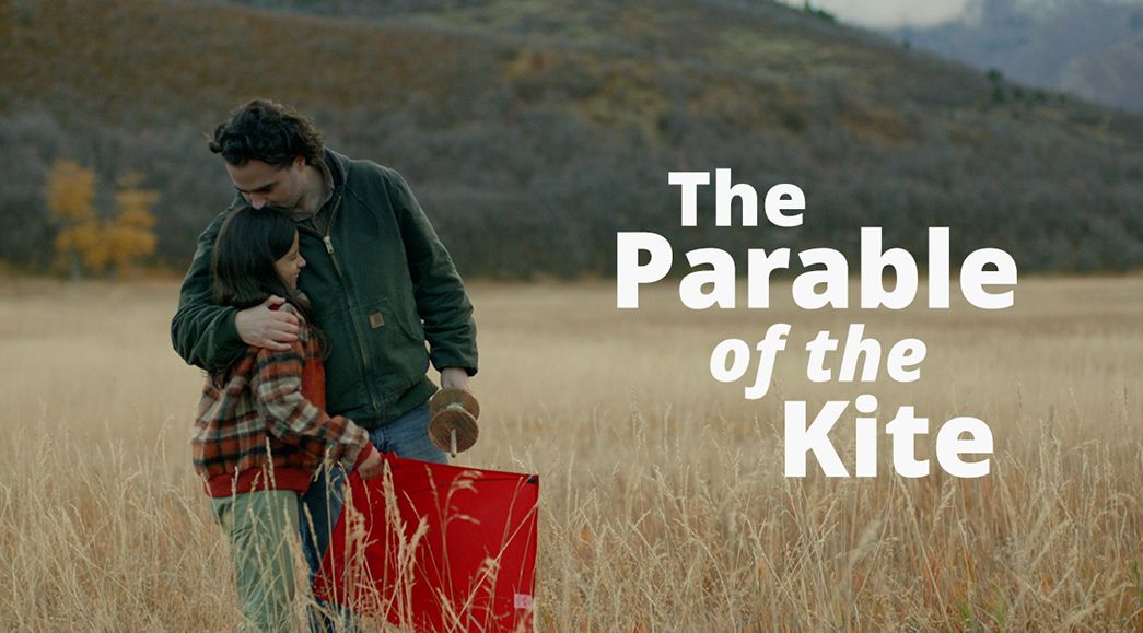 A father with his daughter in a field hold a kite in the Parable of the Kite video