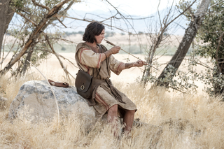Nephi making a bow and arrow in the wilderness
