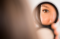 Mixed race woman admiring herself in compact mirror