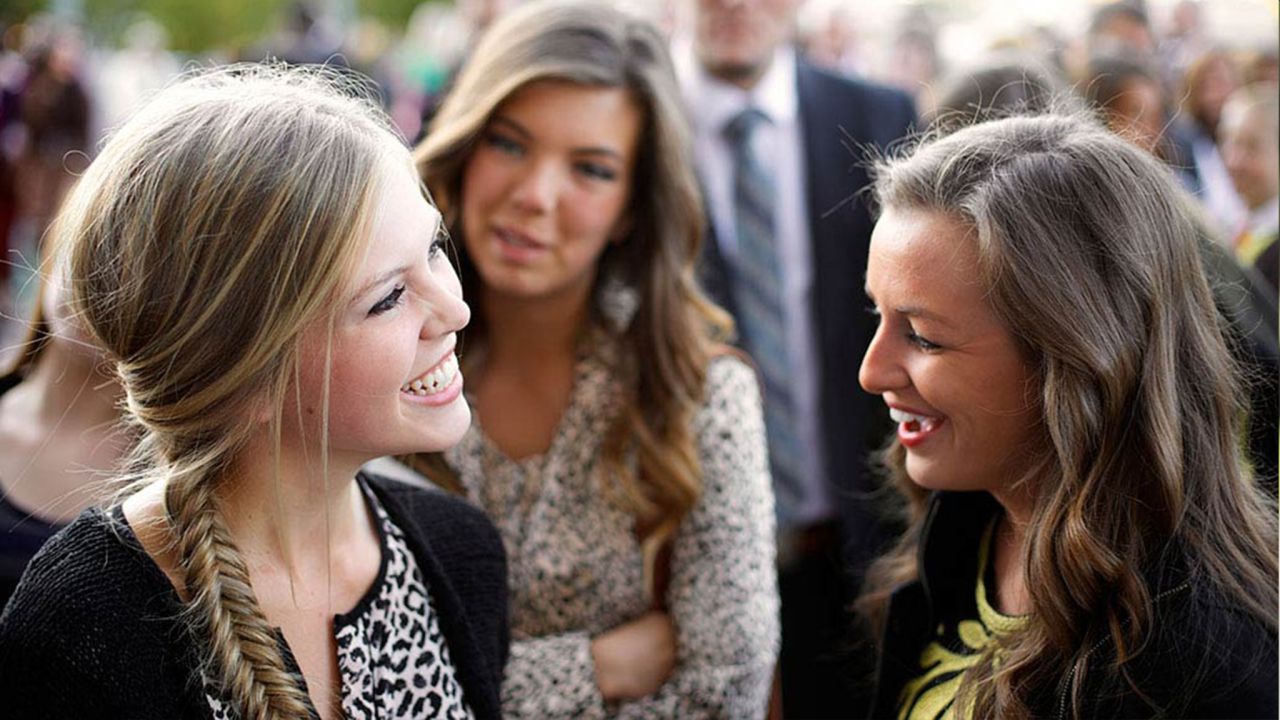 Women greet each other outside of a church building