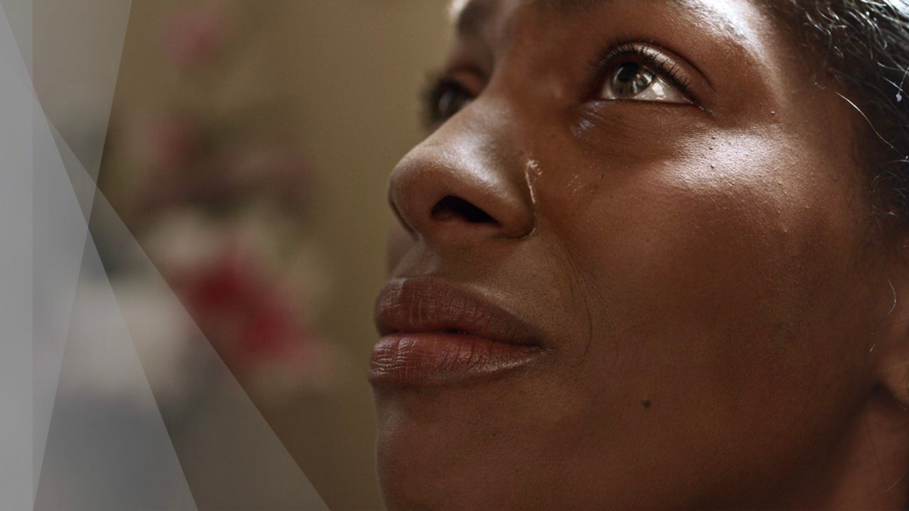 A woman looks up with tears in her eyes