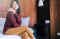 Young Woman Sitting on The Edge of a Bed