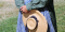 woman standing holding hat