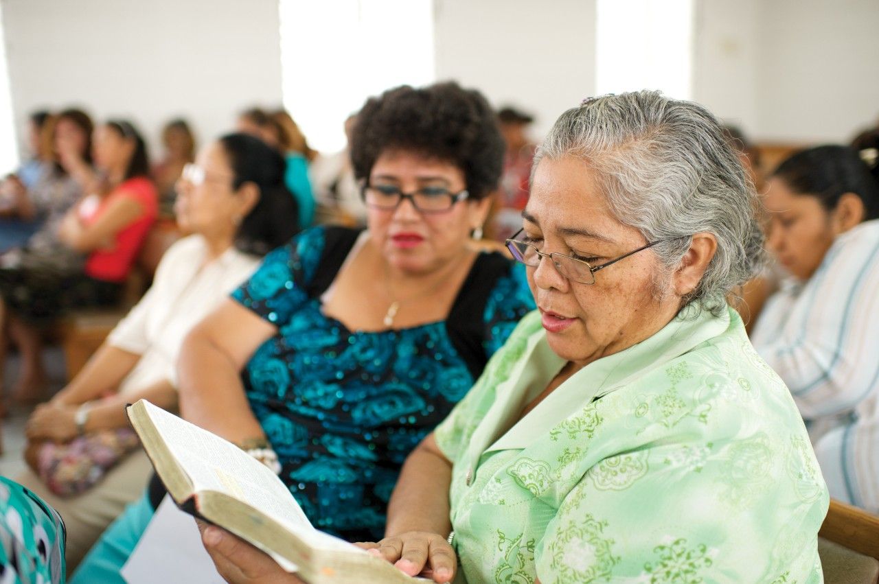 A woman holding scriptures at church in Ecuador.