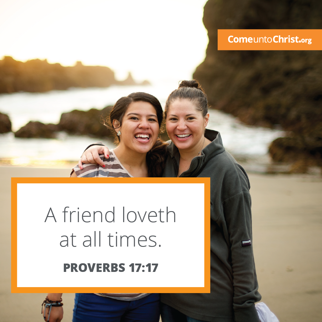Two friends stand together on a beach